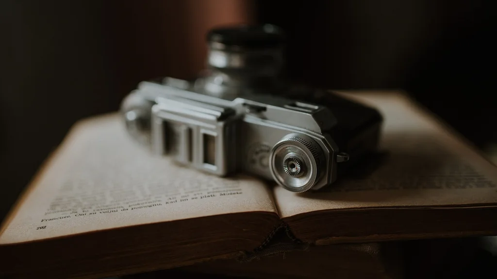 Una macchina fotografica analogica appoggiata su un vecchio libro