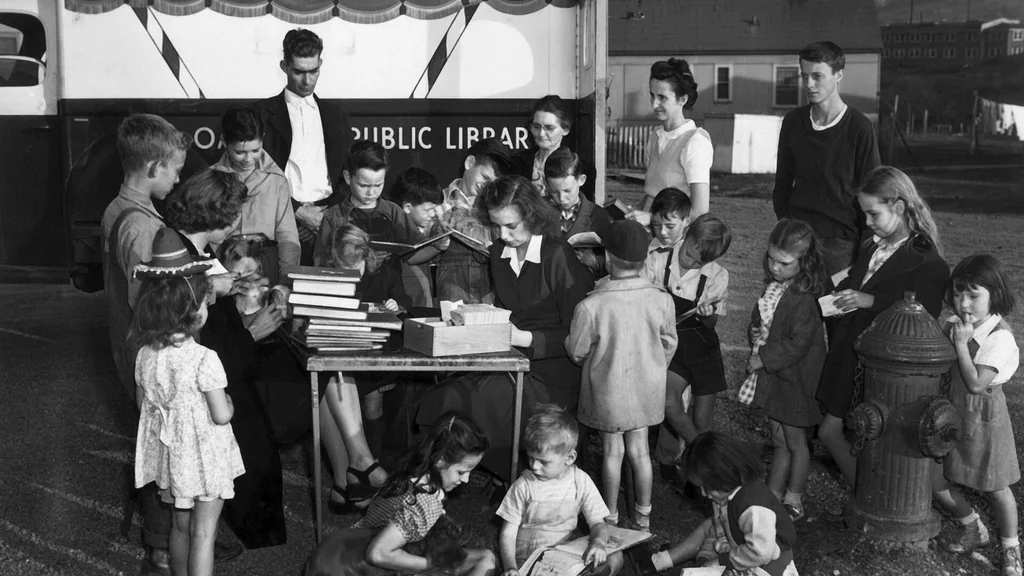 Persona che legge un libro seduta in una biblioteca